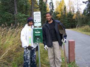 Couple standing next to Mutt Mitt post