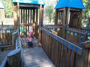 Kids on wooden playground bridge