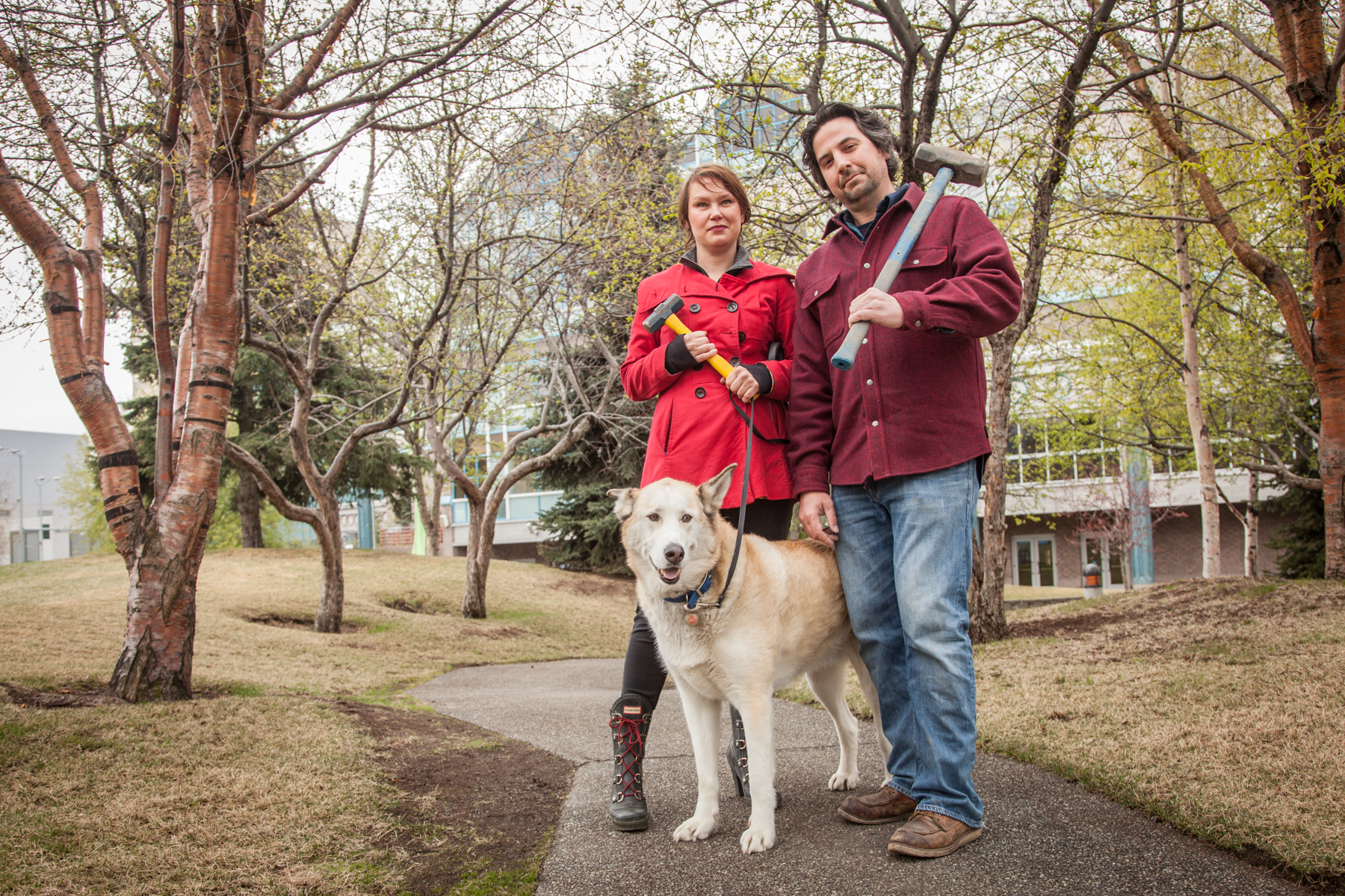 Couple standing on trail with hammers and a dog