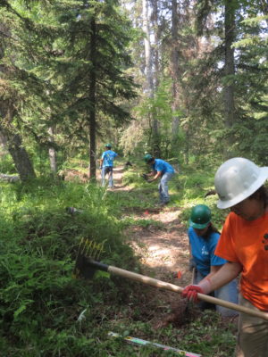 Teen in hard hats clearing trail