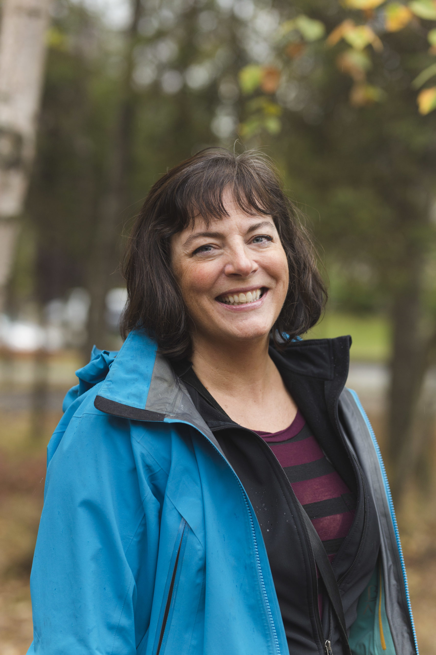 Smiling woman stands in a forest