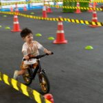 kid playing balance bike in racetrack, speed motion blur image